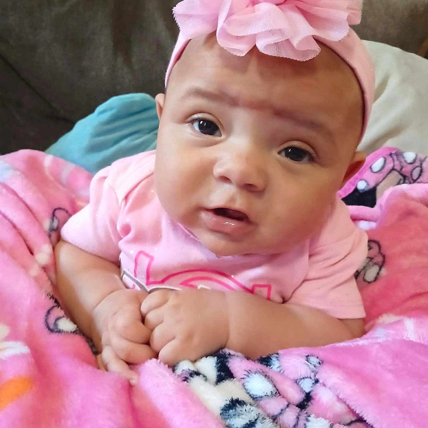 Shalyssa is registered to the contest to win money with this photo: baby, blanket, child, closeup, clothing, comfortable, couch, cute, expression, face, hands, headwear, indoors, infant, person, pink_headband, portrait, resting, soft_fabric, toddler