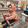toddler, child, shopping_cart, hoodie, polka_dot_pants, indoor, store, menu, shopping, cute, baby, seatbelt, clothing, person, retail, grocery, floor, face, hands, curious