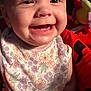 Layla is registered to the contest to win money with this photo: baby, smiling, face, bib, floral_pattern, child, closeup, joyful, happy, plush_toy, colorful, infant, portrait, cute, apparel, young_child, human, expression, skin, indoors