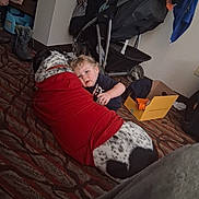 Cash joined the competition — help win amazing prizes! toddler, dog, red_shirt, carpet, indoor, child, pet, stroller, box, clothing, floor, curly_hair, animal, resting, cozy, home, toy, patterned, casual, curious