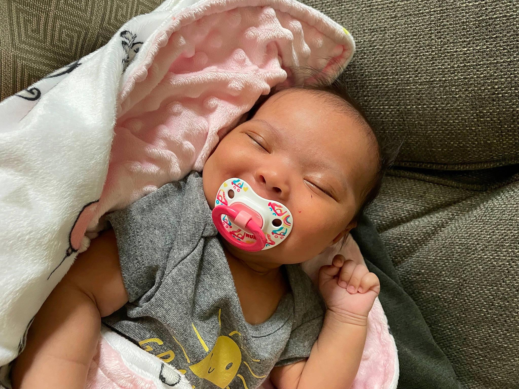 Miley is registered to the contest to win money with this photo: baby, baby_products, baby_toddler_clothing, cheek, child, chin, comfort, eye, finger, hand, happy, head, iris, lip, mouth, nose, person, skin, textile, thumb