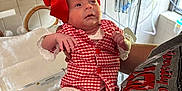 Becklynn is registered to the contest to win money with this photo: arm, baby, bedroom, bracelet, cute, face, footwear, gown, hand, healthcare, hospital, hospital_bassinet, indoor, infant, medical_equipment, newborn, parent, person, red_bow, red_checkered_outfit
