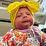 Becklynn joined the competition — help win amazing prizes! apparel, baby, bow, child, close_up, colorful, cute, expression, face, floral_clothing, head_wrap, headwear, indoor, infant, onesie, person, portrait, skin, yellow, young_child