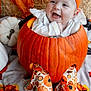 Everleigh is registered to the contest to win money with this photo: baby, pumpkin, orange_bow, white_clothing, happy, smiling, fall, autumn, blanket, decorations, feet, child, cute, holiday, festive, sitting, face, headwear, cozy, seasonal
