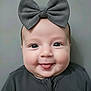 baby, background, bow, cheeks, child, closeup, clothing, cute, eyes, face, fashion, gray, happy, headwear, infant, person, portrait, smile, tongue, young