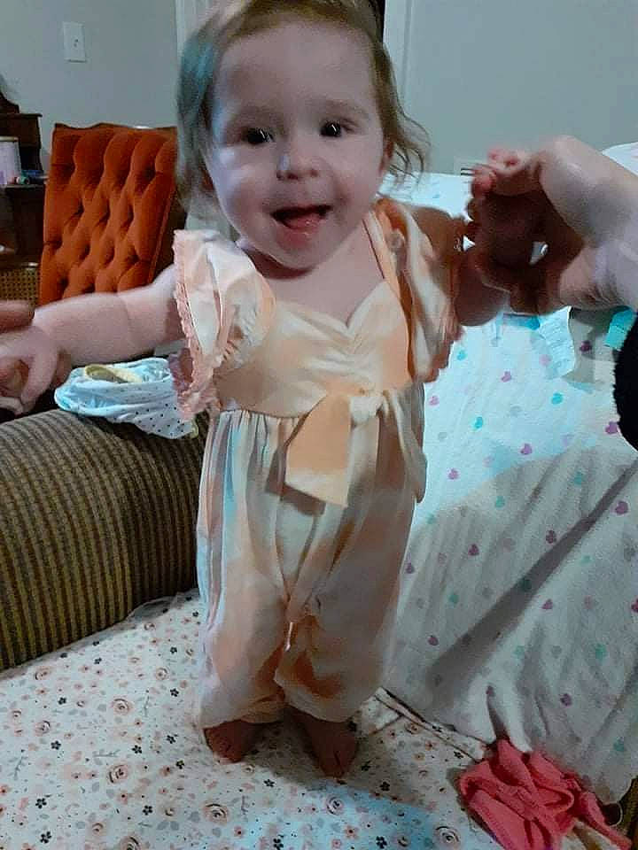 Rayna is registered to the contest to win money with this photo: baby, baby_toddler_clothing, cheek, child, comfort, couch, day_dress, dress, face, finger, gesture, hairstyle, happy, head, person, pink, skin, sleeve, smile, textile