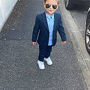 Adam participe au concours pour gagner de l'argent avec cette photo : child, boy, sidewalk, suit, sunglasses, street, car, vehicle, urban, casual, fashion, footwear, pavement, outdoor, person, confident, young, smiling, hair, clothing