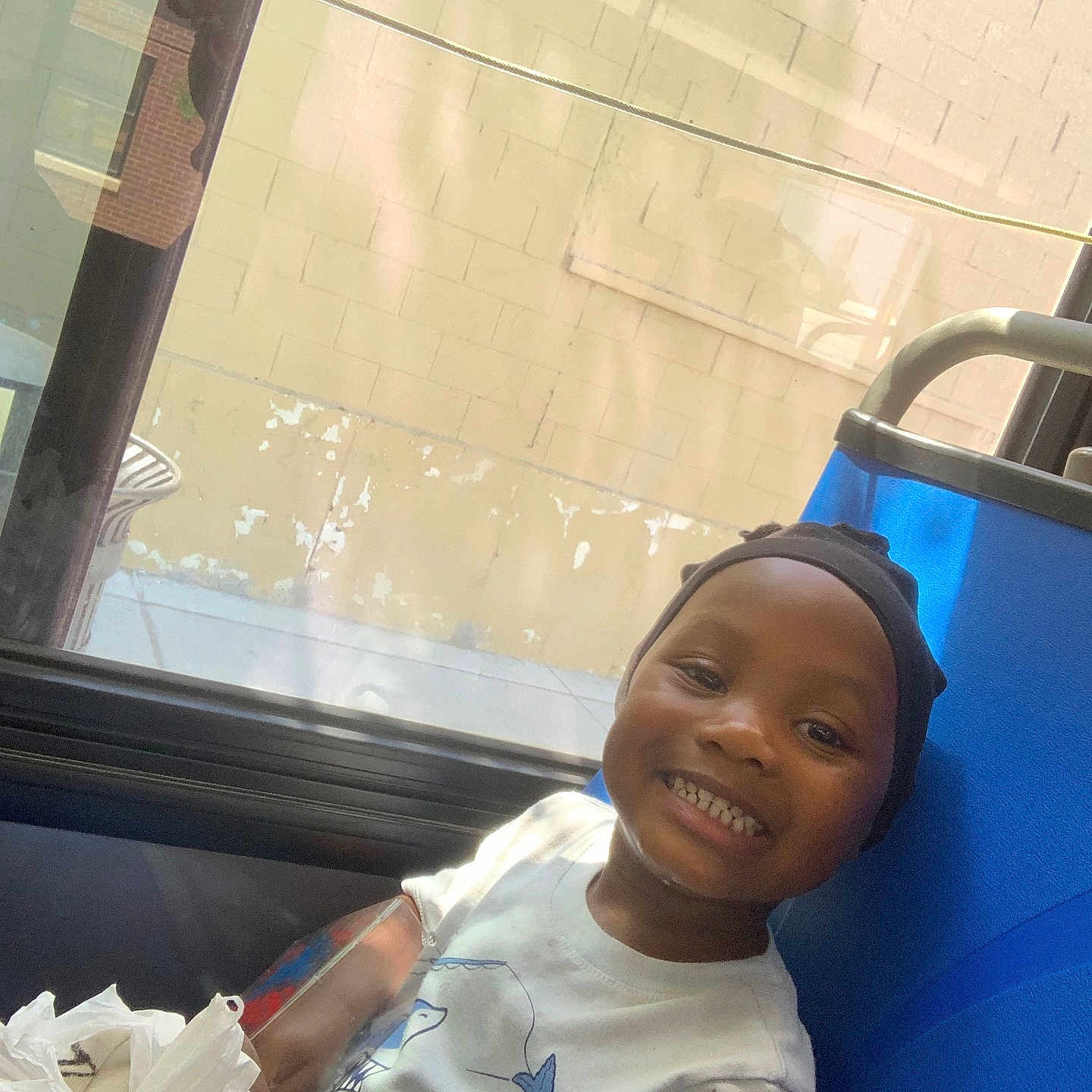 Aijalon is registered to the contest to win money with this photo: blue_seat, boy, candid, cap, casual, child, daylight, happy, indoor, person, plastic_bag, portrait, reflection, seat, shirt, sidewalk, smiling, starfish, wall, window