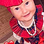 toddler, child, smile, red_bow, headband, plaid, necklace, white_shoes, sitting, indoor, wooden_wall, happy, cute, fashion, clothing, portrait, baby, accessory, red, heart_emoji