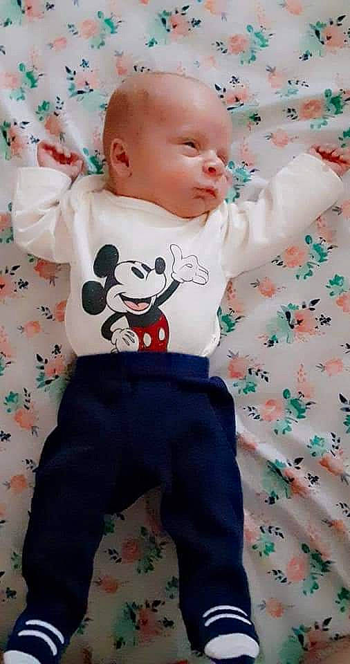 Finnigan is registered to the contest to win money with this photo: baby, baby_products, baby_toddler_clothing, cheek, child, grass, happy, linens, pattern, people, person, pink, play, product, sitting, sleeve, t_shirt, textile, toddler, toy