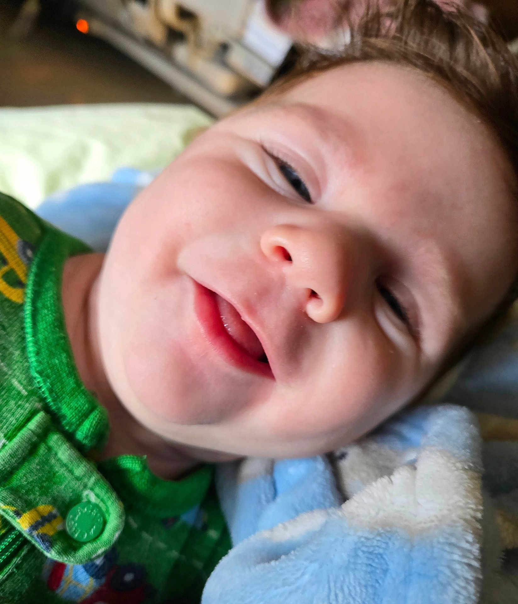 Leo joined the competition — help win amazing prizes! baby, child, smile, face, closeup, blanket, green_clothing, infant, happy, cute, soft_texture, portrait, lying_down, indoors, young_child, skin, eyelashes, button, fabric, expression