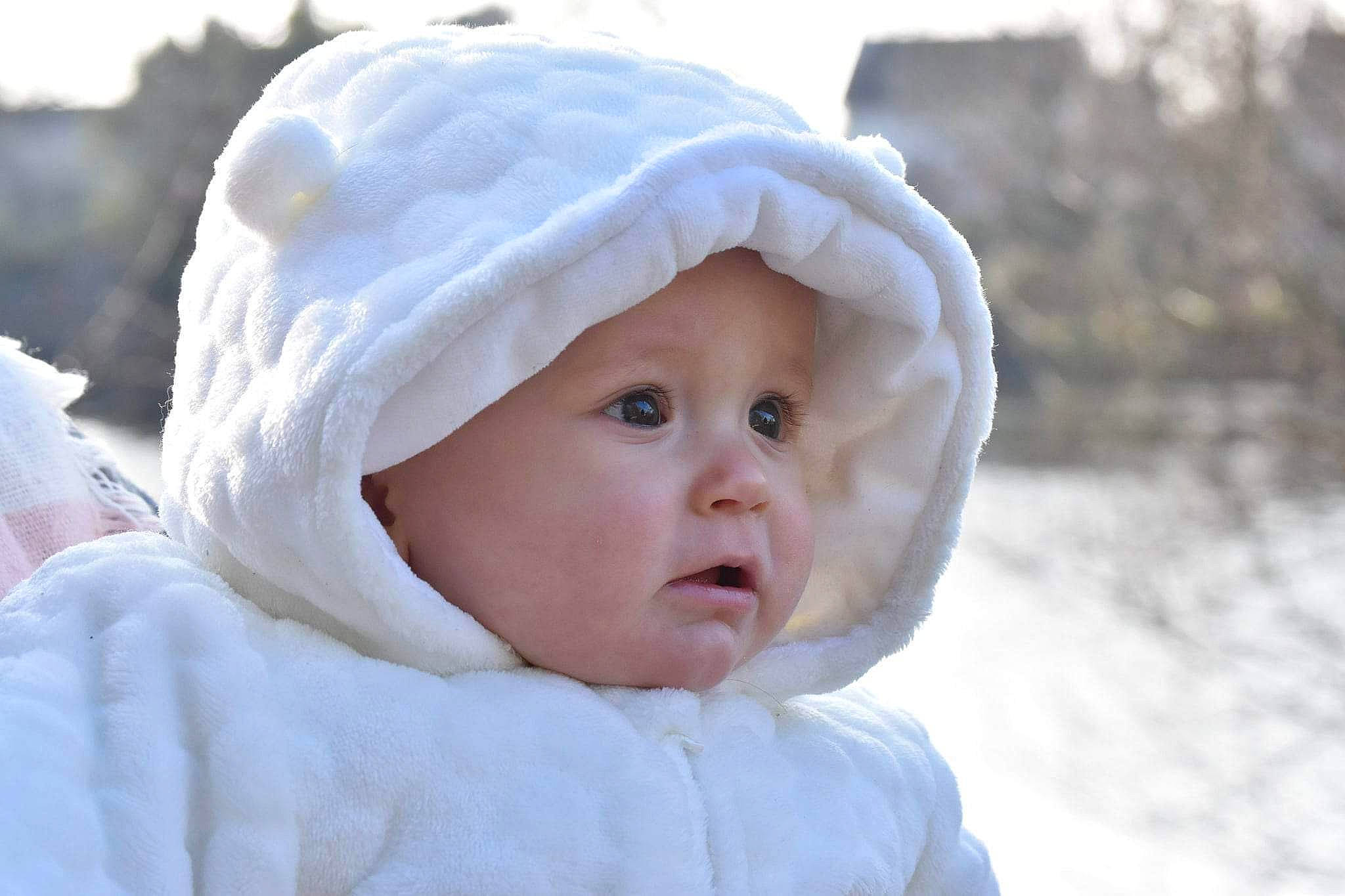 Leyann participe au concours pour gagner de l'argent avec cette photo : baby, baby_toddler_clothing, bonnet, cheek, child, comfort, freezing, fun, fur, happy, headwear, hood, hoodie, knit_cap, person, portrait_photography, sky, snow, toddler, winter