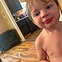 Ryland joined the competition — help win amazing prizes! child, toddler, face, bare_chest, indoor, floor, kitchen, cabinet, clock, window, light, wood_floor, furniture, smile, curious, person, young_child, portrait, home, daylight