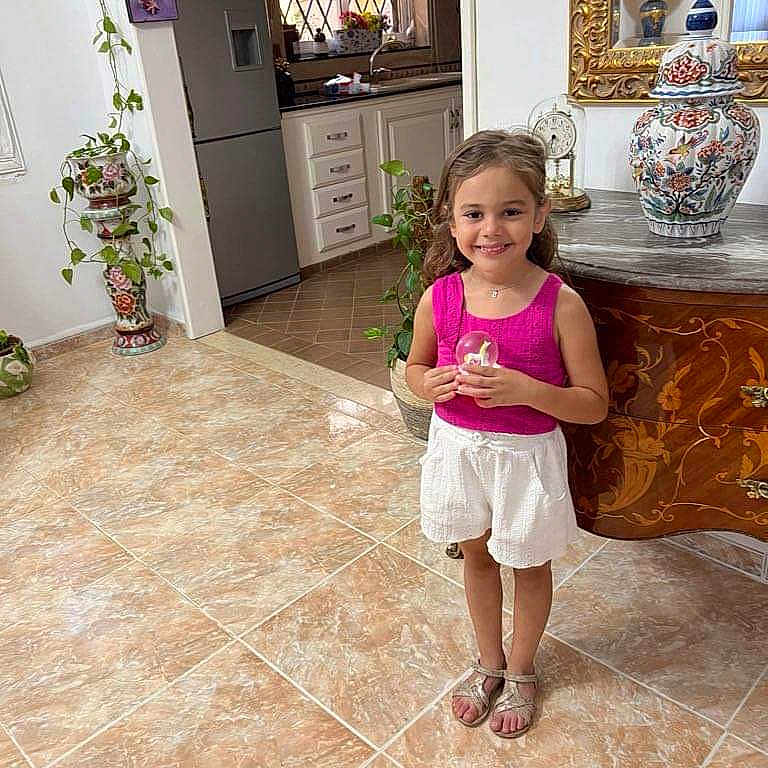 Sirine participe au concours pour gagner de l'argent avec cette photo : child, clothing, face, female, flower, footwear, furniture, girl, head, indoors, interiordesign, jar, person, plant, pottedplant, shoe, shorts, table, tile, wood