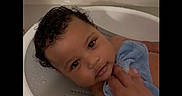 Fidel is registered to the contest to win money with this photo: baby, child, toddler, bath, bathtub, water, wet_hair, curly_hair, face, hand, cloth, blue_cloth, skin, looking_at_camera, indoor, infant, portrait, young_child, cleaning, care