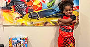 Euzaius joined the competition — help win amazing prizes! child, birthday, balloons, hot_wheels, toys, banner, celebration, smiling, indoor, colorful, gift_boxes, red, orange, blue, black, racing_cars, wall, floor, happy, clothing