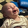 baby, blue_chair, candid, checkered_floor, child, chubby_cheeks, close_up, clothing, cream_shirt, cute, happy, heart_shape, indoor, infant, laughing, leopard_print, person, portrait, smile, soft_light