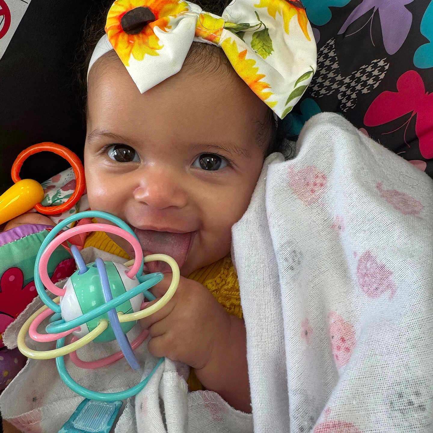 Pheby joined the competition — help win amazing prizes! baby, blanket, bow, butterfly, child, closeup, clothing, colorful, cute, face, happy, headband, indoors, infant, pattern, playful, portrait, smiling, tongue_out, toy