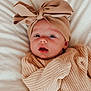 baby, infant, child, knitted_sweater, headwrap, bow, blanket, soft_texture, face, portrait, cute, cozy, warm_clothing, lying_down, indoors, closeup, expression, wide_eyes, skin, newborn