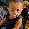 Emil joined the competition — help win amazing prizes! toddler, child, baby, indoor, sitting, black_shirt, blue_pants, toy, bed, blanket, curly_hair, skin, face, expression, hands, casual_clothing, home, cozy, portrait, cute