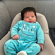 Swan a rejoint le concours — aidez-le/la à gagner de superbes lots ! baby, infant, child, blue_clothing, cat_design, paw_prints, cushion, sofa, indoor, portrait, cute, hair, relaxed, seated, home, soft_fabric, face, hand, footwear, plush