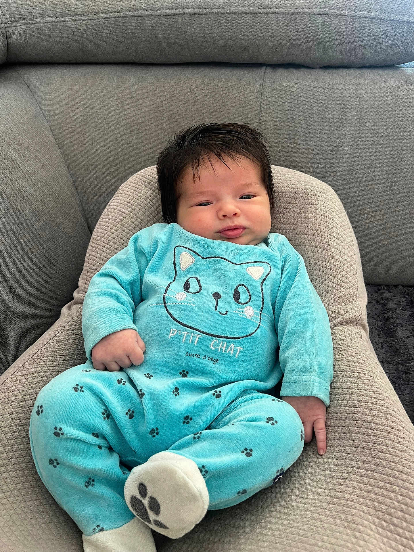 Swan a rejoint le concours — aidez-le/la à gagner de superbes lots ! baby, infant, child, blue_clothing, cat_design, paw_prints, cushion, sofa, indoor, portrait, cute, hair, relaxed, seated, home, soft_fabric, face, hand, footwear, plush