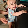 Gabriel joined the competition — help win amazing prizes! baby, smile, standing, onesie, couch, hands, indoor, floor, support, pillow, furniture, person, child, happy, face, home, light, skin, cute, young