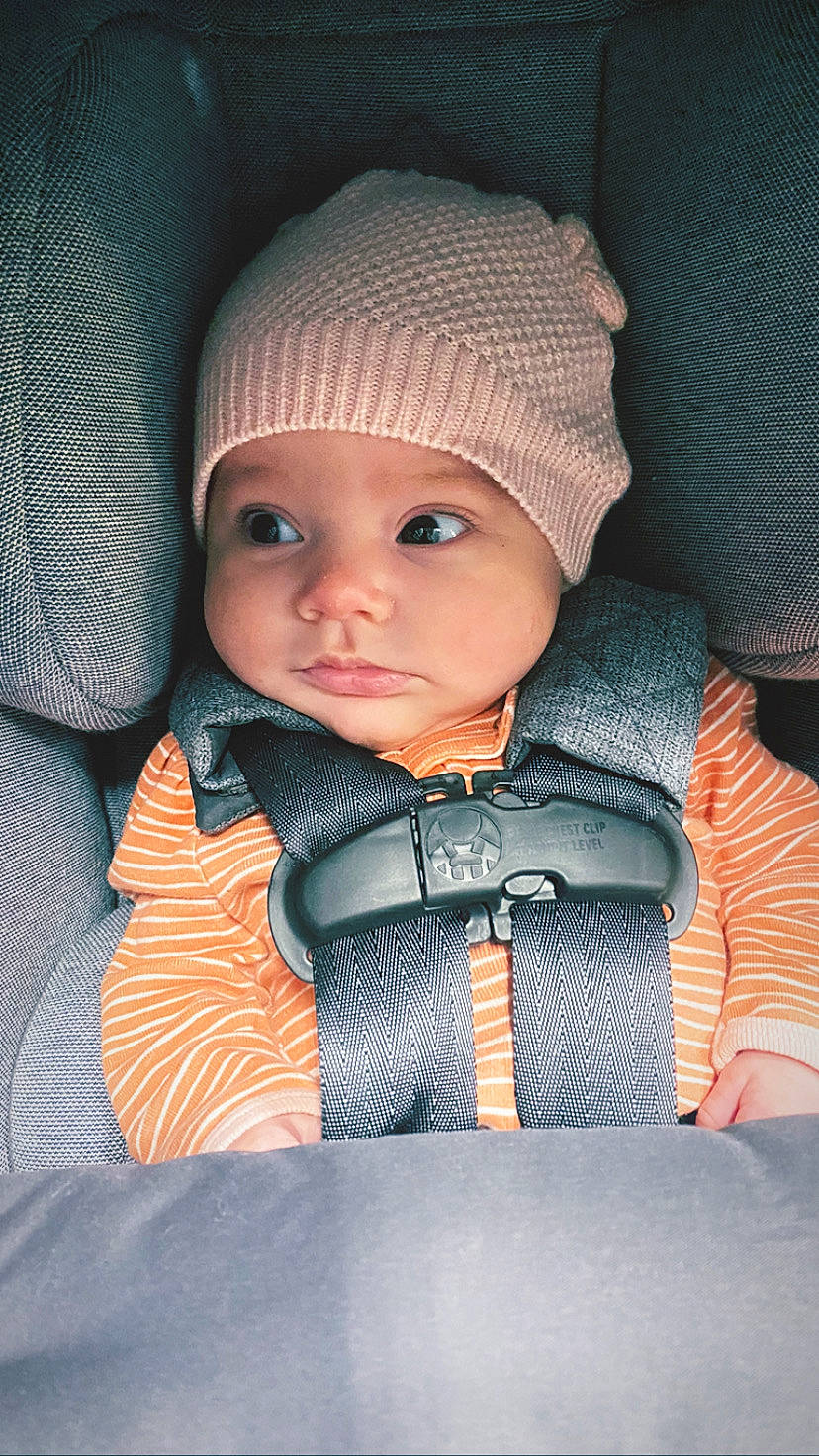 Hazel is registered to the contest to win money with this photo: baby, baby_carriage, baby_products, baby_toddler_clothing, cap, cheek, child, comfort, cool, electric_blue, eyebrow, fashion_accessory, flash_photography, headwear, knit_cap, outerwear, person, sitting, skin, sleeve