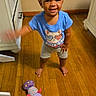 Elizabeth joined the competition — help win amazing prizes! toddler, child, smiling, blue_tshirt, barefoot, wooden_floor, toy, plush_toy, caterpillar_toy, indoor, cabinet, furniture, curly_hair, happy, person, standing, playful, cute, home, floor
