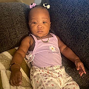 Lyndon joined the competition — help win amazing prizes! baby, infant, child, couch, blanket, clothing, purple_top, floral_pants, hair_bows, bracelet, gold_chain, face, relaxing, indoors, person, portrait, cute, comfort, seated, home