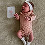 baby, infant, newborn, carpet, headband, pink_clothing, white_socks, lying_down, card, age_card, one_month, cute, small_hands, small_feet, indoor, soft_texture, portrait, child, person, yawning