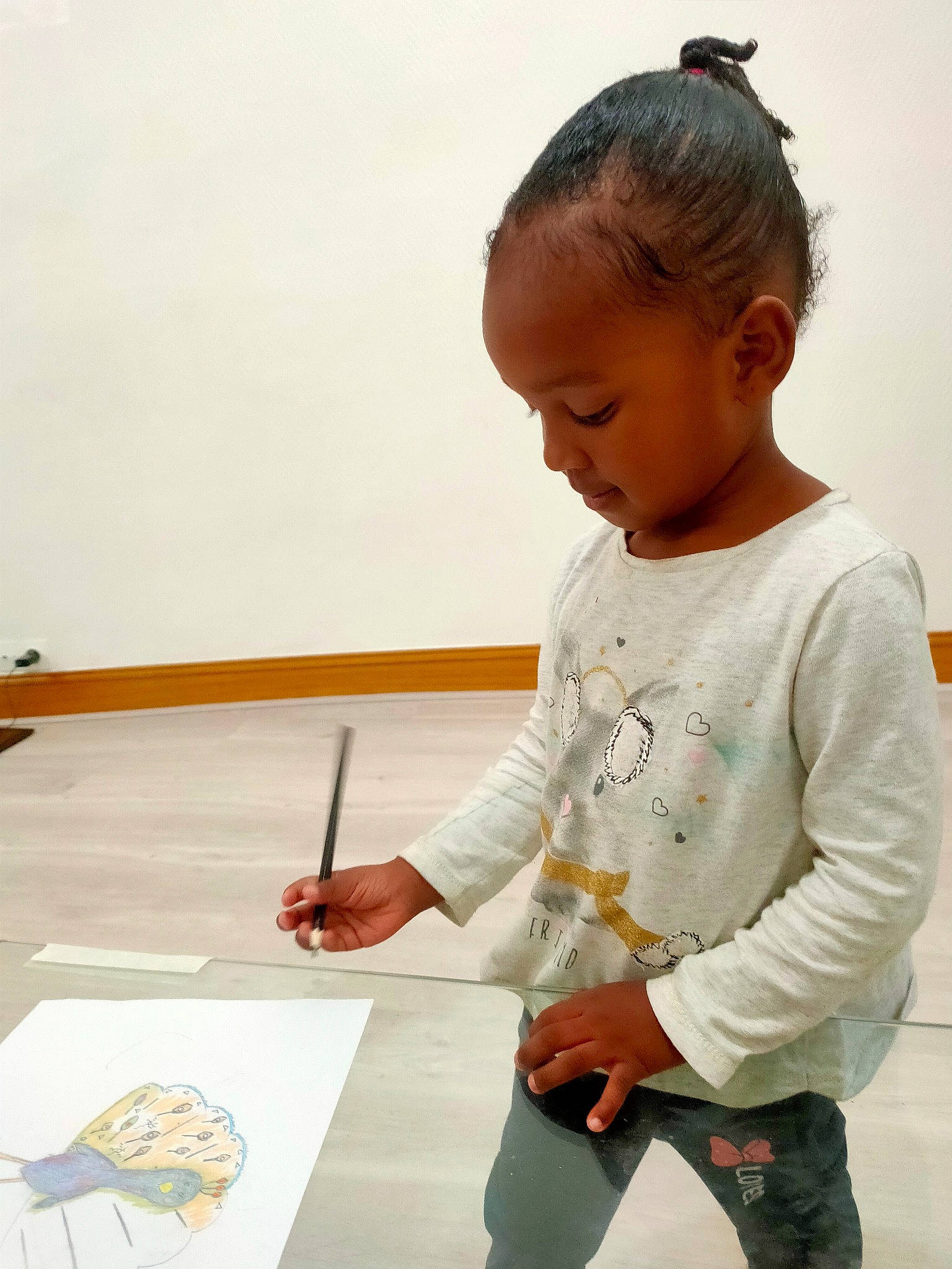 Paloma participe au concours pour gagner de l'argent avec cette photo : artist, child, child_art, drawing, easel, flooring, office_instrument, office_supplies, paint, person, sitting, sleeve, standing, t_shirt, table, toddler, visual_arts, wood, writing, writing_implement