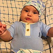 Orion joined the competition — help win amazing prizes! baby, infant, child, hat, clothing, patterned_clothes, blanket, checkered, face, hands, cute, lying_down, expression, pajamas, blue, white, indoor, soft_lighting, closeup, person