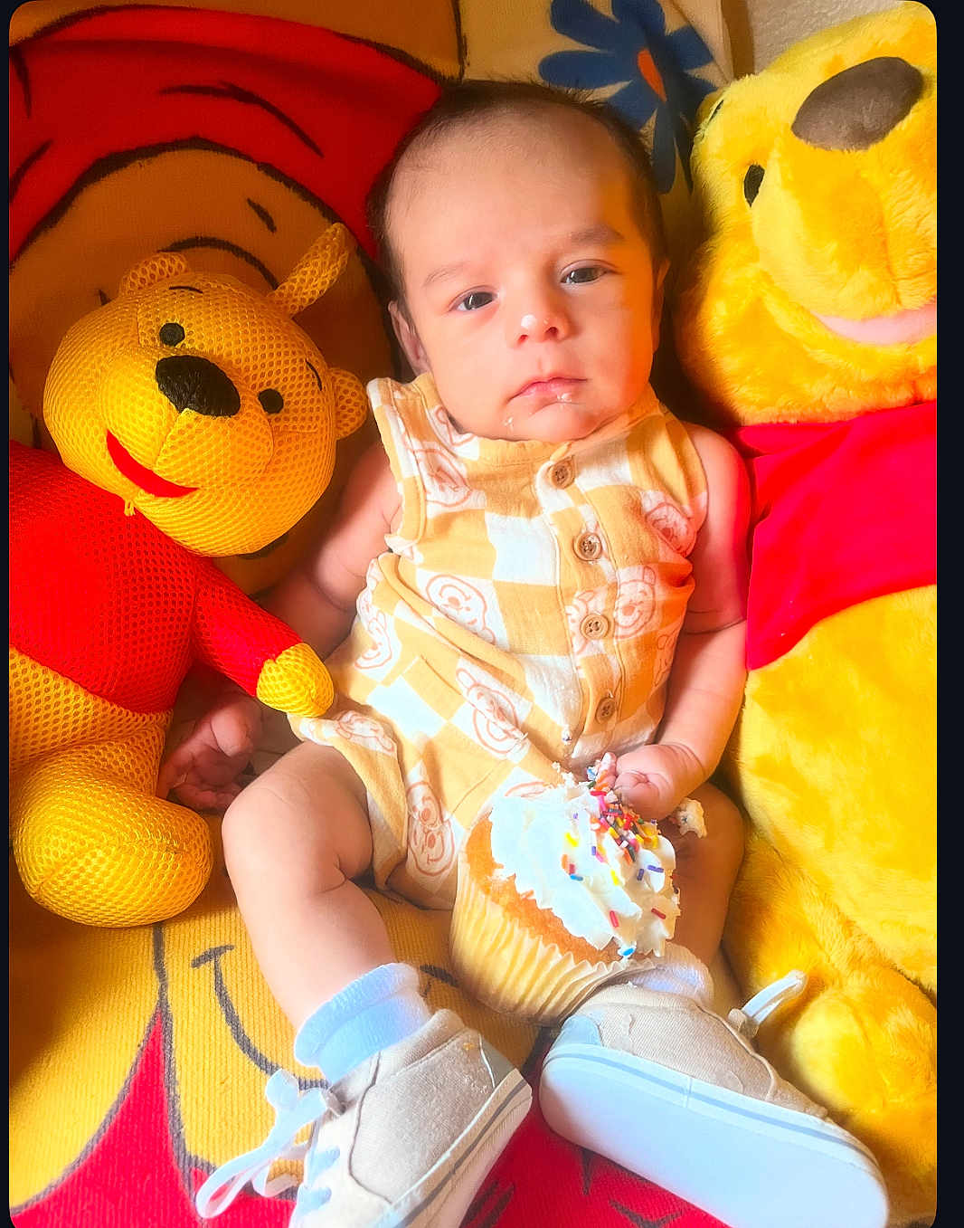 Luka joined the competition — help win amazing prizes! baby, child, cupcake, toy, stuffed_animal, winnie_the_pooh, plush, yellow, red, socks, shoes, face, expression, sitting, indoor, background, patterned_clothing, food, sprinkles, cute