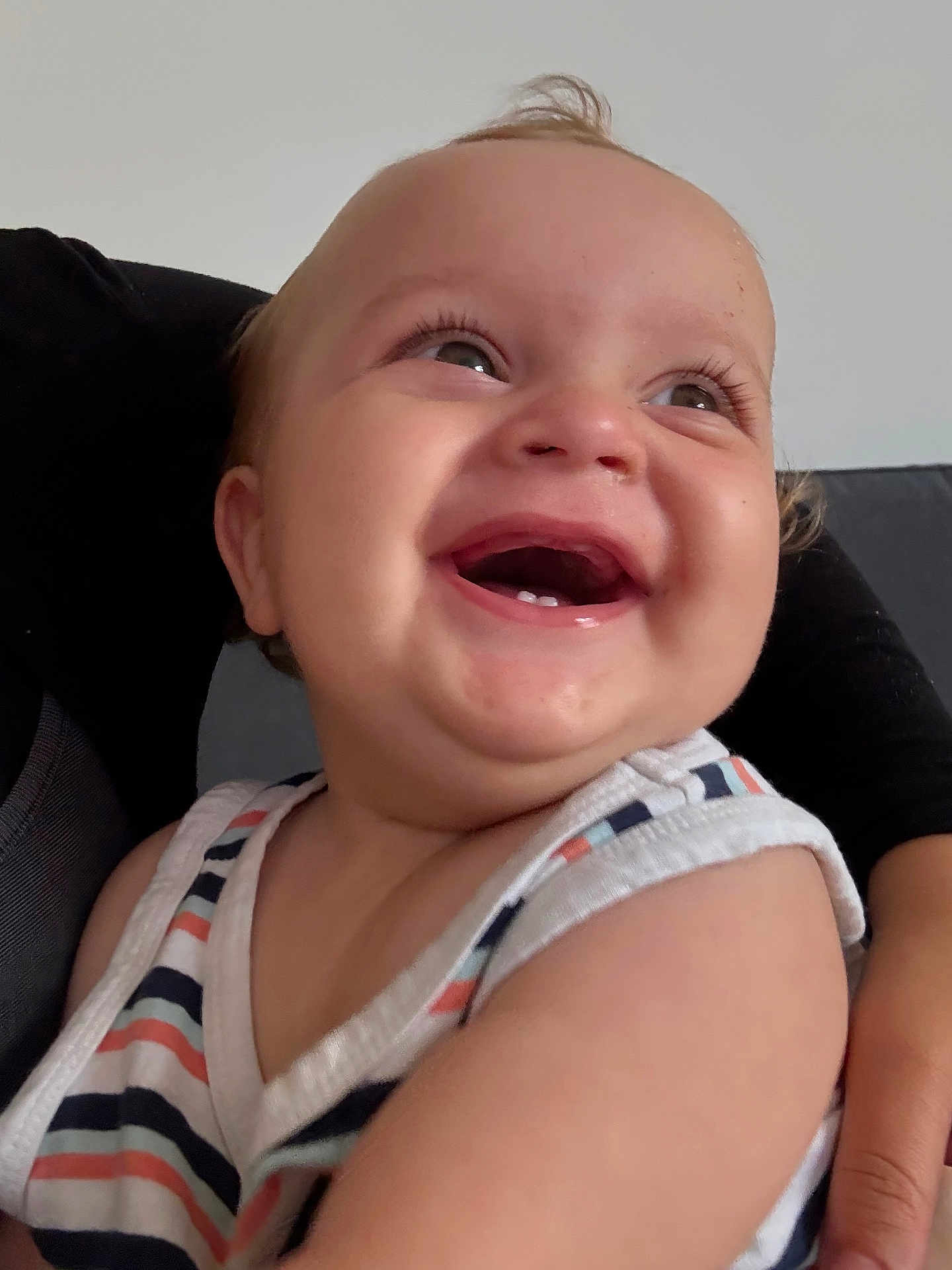 Noah is registered to the contest to win money with this photo: baby, child, smiling, happy, face, teeth, hair, striped_clothing, sleeveless, arm, person, infant, cute, joyful, portrait, skin, human, closeup, expression, indoor