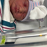 Blakley joined the competition — help win amazing prizes! architecture, baby, bed, blanket, building, clothing, crib, face, furniture, glove, hat, head, hospital, infantbed, newborn, person, photography, portrait, quilt, sleeping