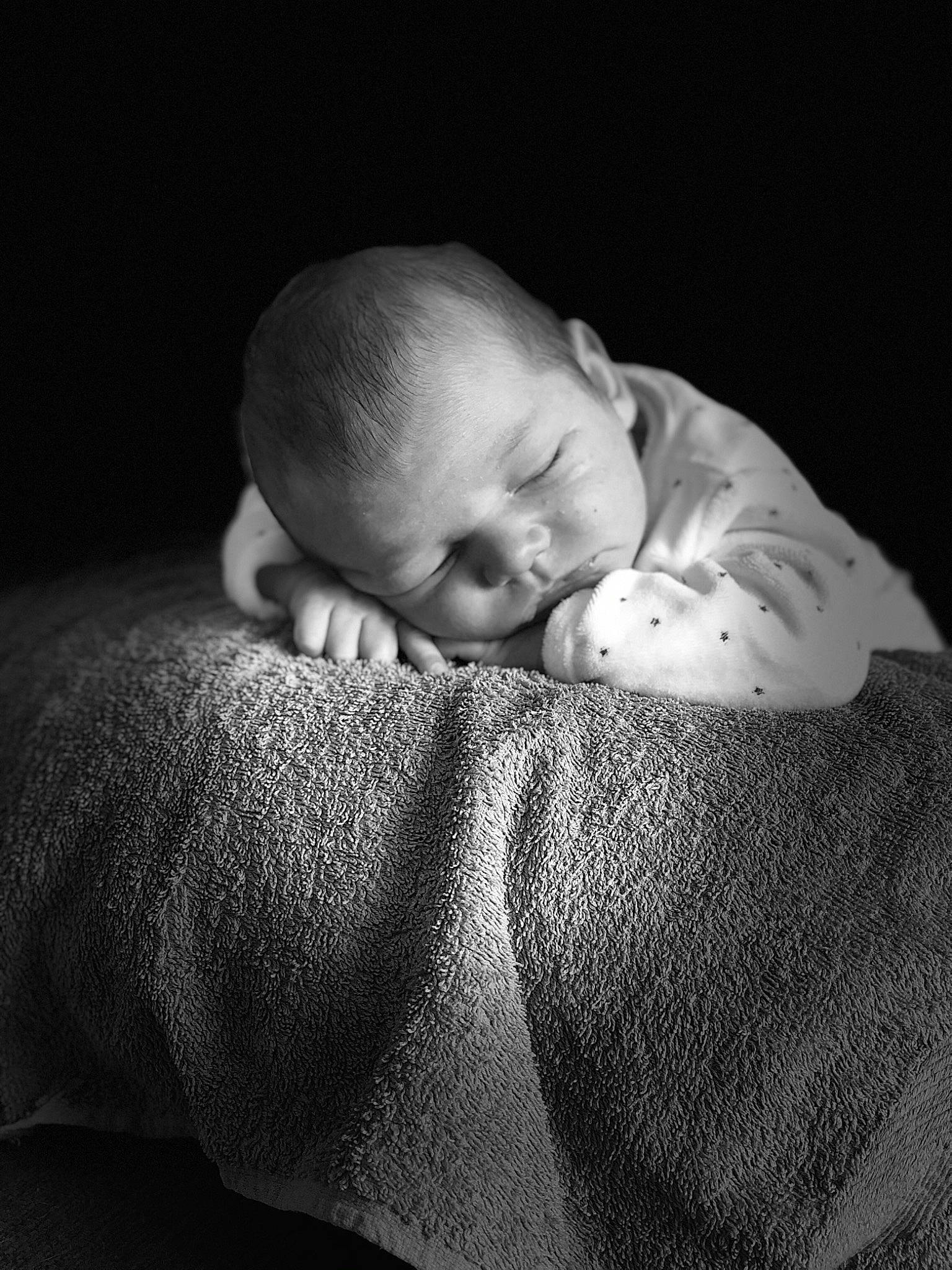 Gabin a rejoint le concours — aidez-le/la à gagner de superbes lots ! arm, baby, baby_toddler_clothing, bedtime, cheek, child, comfort, darkness, eye, flash_photography, hand, happy, human_body, linens, monochrome, monochrome_photography, nose, person, sitting, skin
