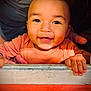baby, child, smile, happy, face, hands, orange_clothing, wooden_ledge, sunlight, portrait, closeup, infant, cute, warm_colors, indoor, person, young_child, expression, skin, eyes