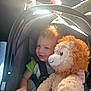 Ashton is registered to the contest to win money with this photo: baby, car_interior, car_seat, casual, child, clothing, hand, happy, infant, lion, person, plush_toy, seat, seatbelt, smile, stuffed_animal, sunlight, toddler, toy, vehicle