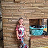 Ma'Kinzie joined the competition — help win amazing prizes! child, girl, smiling, portrait, standing, indoor, fireplace, stone_wall, brick, laundry_basket, clothing, sunflower, patterned_outfit, hair_bows, wooden_floor, home, living_room, family_photo, full_body, casual_pose