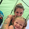 child, adult, smiling, portrait, camping, tent, outdoor, family, parent, daughter, girl, face, eyes_closed, blonde_hair, braids, tattoo, camping_gear, tent_interior, selfie, photograph