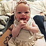 Tyana participe au concours pour gagner de l'argent avec cette photo : arm, baby, bed, blanket, clothing, cute, dress, face, hand, happy, headband, heart_pattern, home, indoor, infant, infant_fashion, person, skin, smiling, tattoo