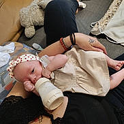 Tyana participe au concours pour gagner de l'argent avec cette photo : baby, blanket, bottle, bracelet, casual, closeup, clothing, comfort, couch, fabric, feeding, floor, foot, hand, headband, indoor, infant, person, relaxation, tattoo