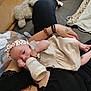 baby, blanket, bottle, bracelet, casual, closeup, clothing, comfort, couch, fabric, feeding, floor, foot, hand, headband, indoor, infant, person, relaxation, tattoo