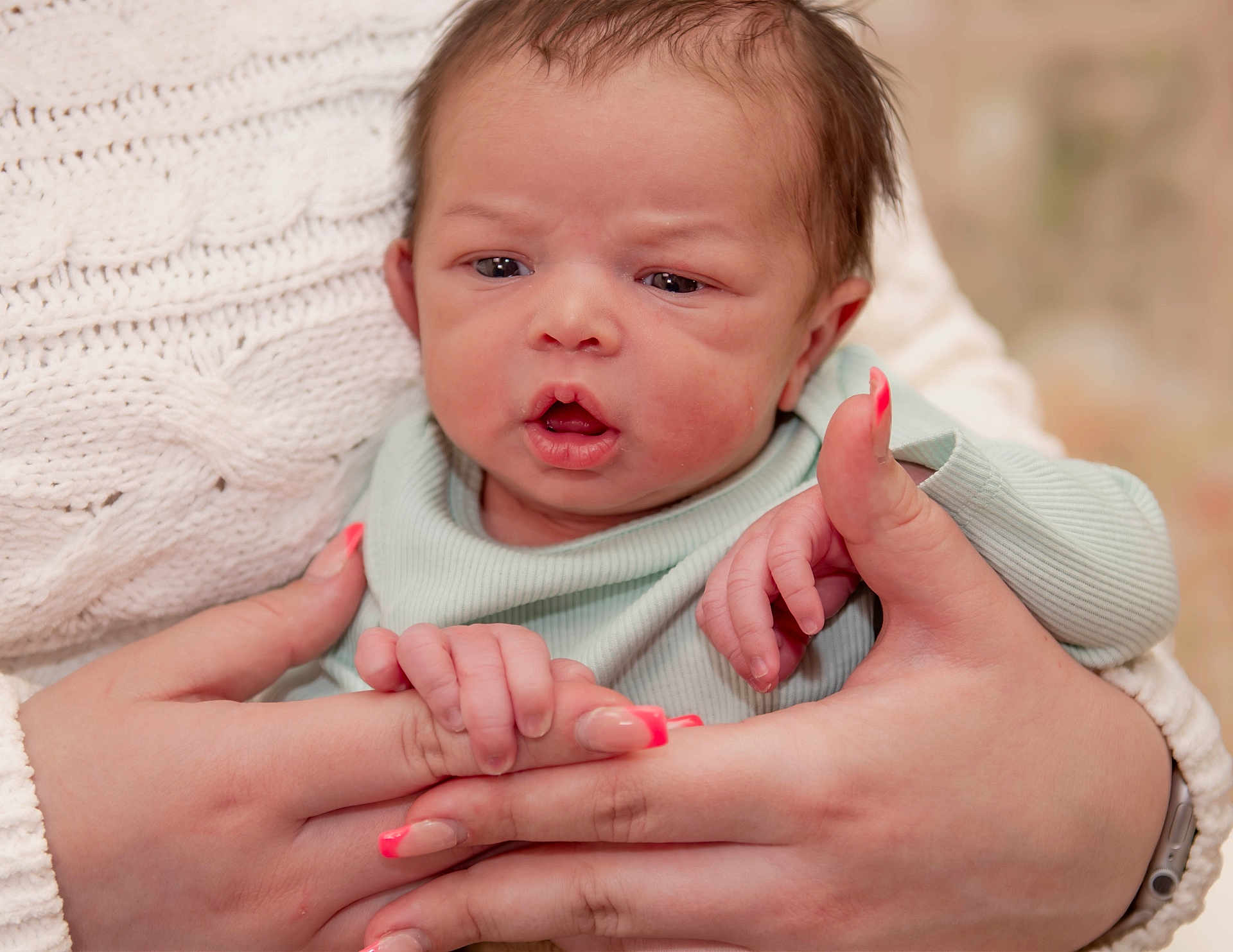 Kingston is registered to the contest to win money with this photo: baby, newborn, infant, face, hand, hands, nail_polish, nails, holding, cuddling, blanket, knit_sweater, portrait, close_up, mouth_open, expression, skin, cozy, soft_texture, caregiver