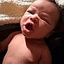 Kingston is registered to the contest to win money with this photo: baby, newborn, infant, face, mouth_open, yawning, blanket, skin, torso, portrait, closeup, expression, hair, indoors, soft_texture, cozy, lighting, sleepy, cute, human