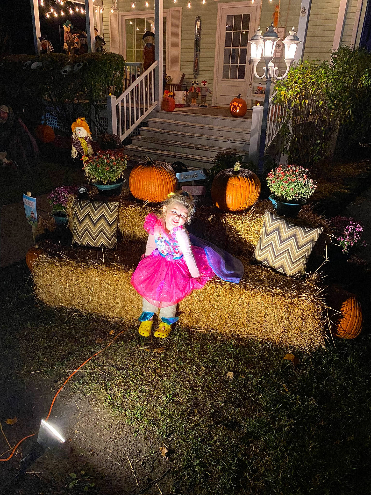 Sienna is registered to the contest to win money with this photo: backyard, door, event, flooring, fun, grass, holiday, leisure, lighting, magenta, night, person, plant, pumpkin, road_surface, sidewalk, street, tints_and_shades, toddler, window