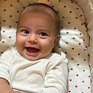 Nitsa is registered to the contest to win money with this photo: baby, smile, face, infant, cute, blanket, heart_pattern, clothing, white_outfit, happy, lying_down, closeup, child, skin, head, eyes, mouth, hand, indoors, soft