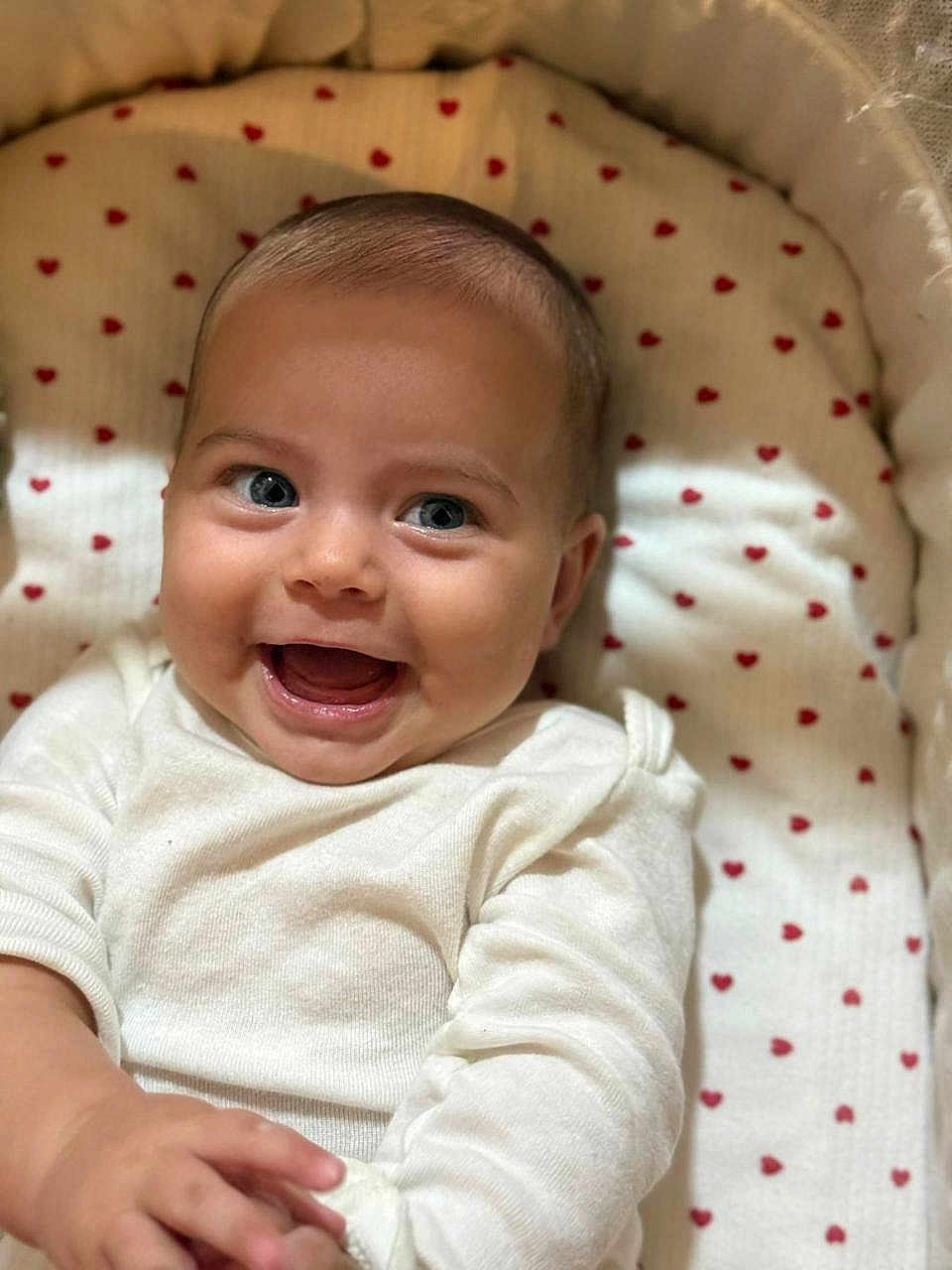 Nitsa is registered to the contest to win money with this photo: baby, smile, face, infant, cute, blanket, heart_pattern, clothing, white_outfit, happy, lying_down, closeup, child, skin, head, eyes, mouth, hand, indoors, soft