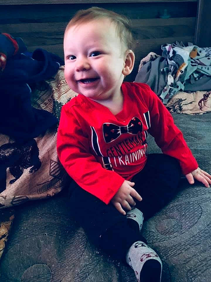 Alexander is registered to the contest to win money with this photo: arm, baby, cheek, child, christmas, cool, face, facial_expression, happy, head, joy, leg, people, person, play, sitting, skin, sleeve, smile, t_shirt